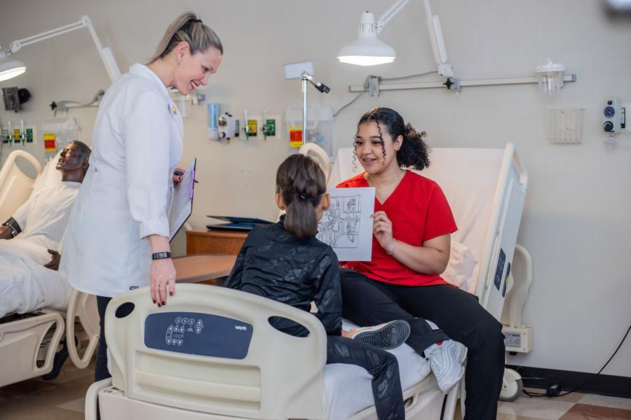 student showing picture to child with instructor