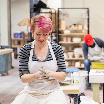 Ceramics student with clay on their hands