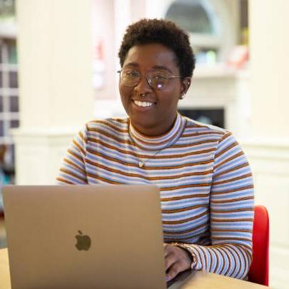 Student poses for photo in harned building