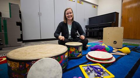 Professor posing with drums in classroom 